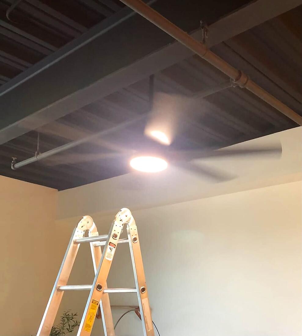 New ceiling fan with LED light installed on a dark exposed ceiling