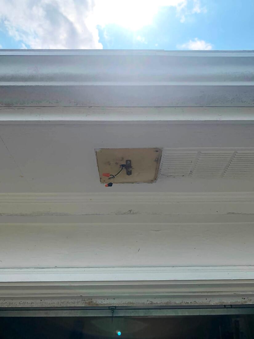 Soffit with the old exterior light removed, ready for a new fixture